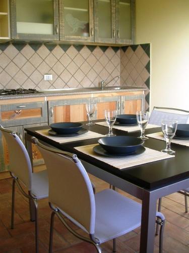 a kitchen with a table with plates and wine glasses at Casavacanze Sant'Eugenia in Attigliano