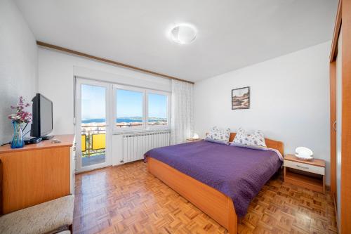 a bedroom with a bed and a large window at Apartmani Patača in Vodice