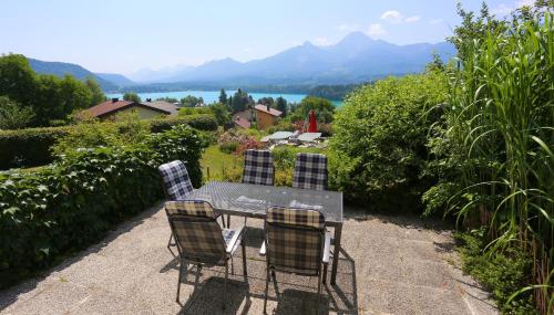a table and chairs with a view of the mountains at Appartementhaus Franz Samonig in Drobollach am Faakersee