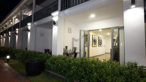 a white building with a table in front of it at Souphattra Hotel Luang Prabang in Luang Prabang