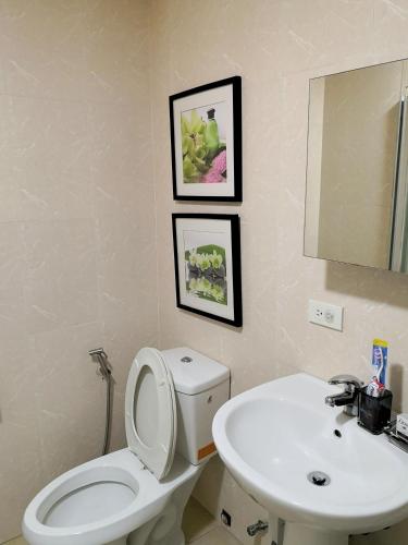 a bathroom with a white toilet and a sink at Avant Apartments at The Fort in Manila