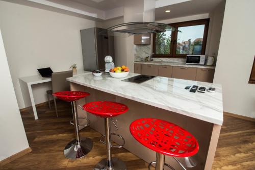 een keuken met rode barkrukken en een aanrecht bij Breeze Guest House in Chernomorets