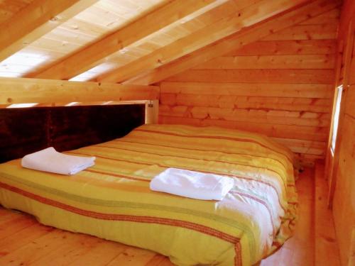 Un dormitorio con una cama en una cabaña de troncos en Villa Rossi, en Enna