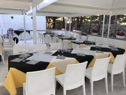 a dining room with white chairs and tables with wine glasses at Hotel Paradiso in Collina in San Giovanni Rotondo