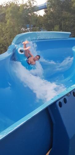 a couple of people swimming in a blue swimming pool at Umuzi Lodge in Secunda