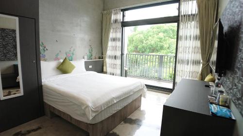 a bedroom with a bed and a large window at Tree House in Hualien City