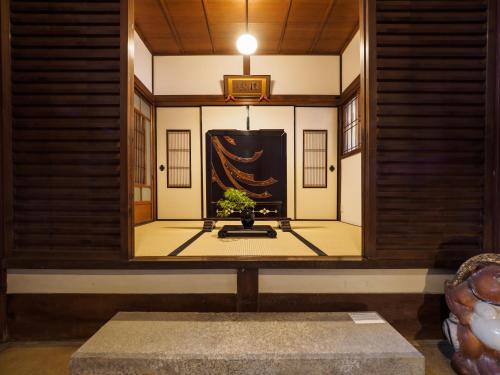 a mirror in a room with a table and a plant at Inase Otsu Machiya Bed and Breakfast in Otsu