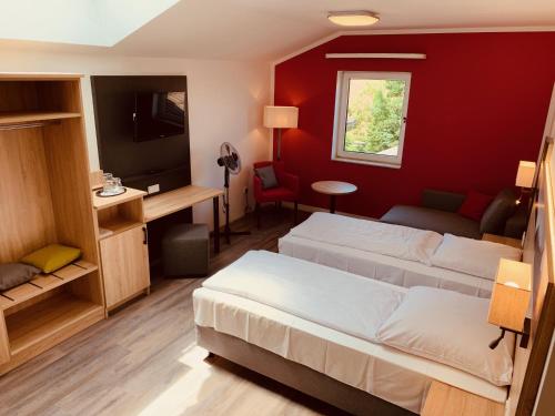 a bedroom with two beds and a red wall at Pension Lindenhof in Grasbrunn