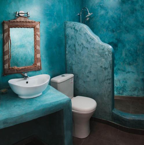 a blue bathroom with a toilet and a sink at Abelomilos Exclusive Villa in Imerovigli