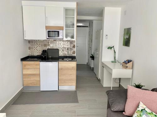 eine Küche mit weißen Schränken und ein Wohnzimmer in der Unterkunft Apartamento Dreamplace in Finestrat