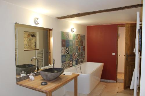 a bathroom with two sinks and a bath tub at Ferme-Château de Cordey & Spa in Cordey