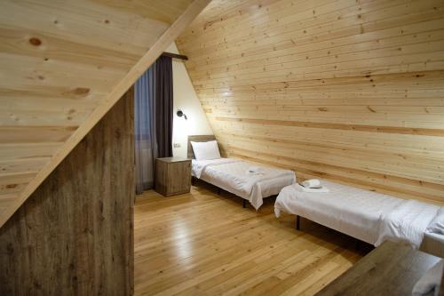 a room with two beds in a wooden wall at Twins Achkhoti in Stepantsminda