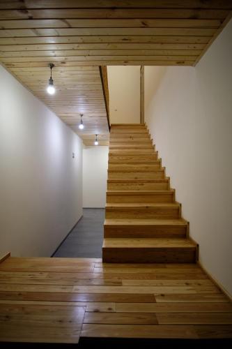 a staircase in a room with wooden floors and ceilings at Hotel TWINS Achkhoti in Stepantsminda
