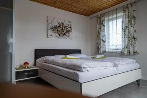 a bedroom with a large white bed with a window at Haus Lebensfreude in Magland