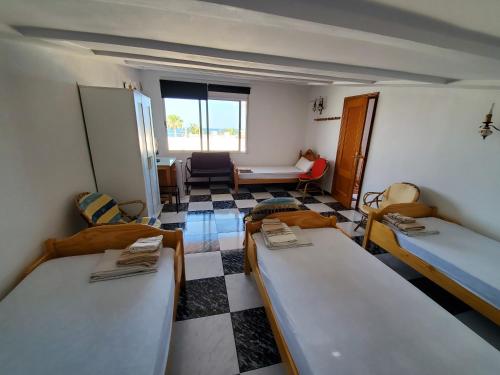 モンコファにあるHouse Mare Nostrumのベッド3台とリビングルームが備わる客室です。