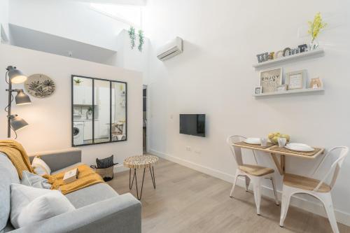 een woonkamer met een bank en een tafel bij La buhardilla in Sevilla