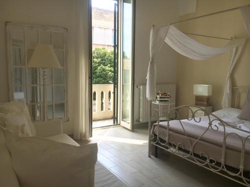 a bedroom with a canopy bed and a large window at Ai Raggi di Sole in Lecce