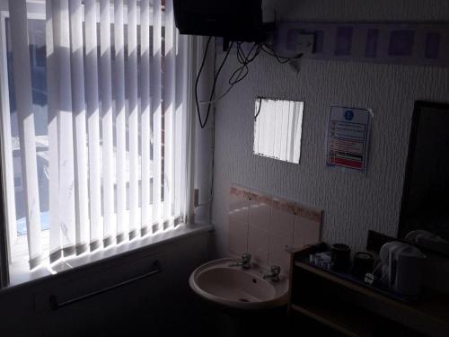 a bathroom with a sink and a large window at Belroy Hotel in Blackpool