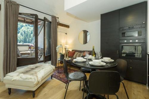 Una sala de estar con una mesa y un comedor. en Apartment Midi Loft - A Central Chamonix Mountain Haven, en Chamonix-Mont-Blanc