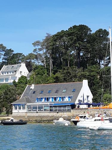 ein großes Gebäude mit im Wasser angedockten Booten in der Unterkunft Hotel Restaurant Les Venetes in Arradon