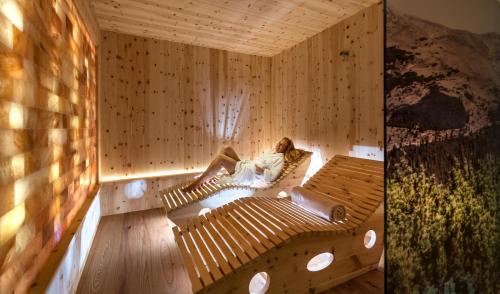 a woman sitting in a sauna reading a book at Bar Garni Reischnhitt des Eschgfeller Christoph in Sarntal