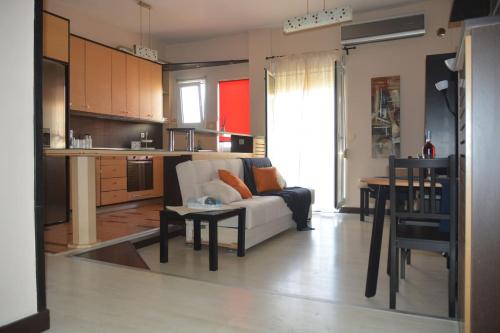 a living room with a couch and a kitchen at Modern apartment, 5΄ walk from central metro station in Athens
