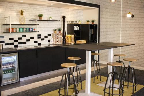 a kitchen with a counter and stools in a room at Novotel Le Mans in Le Mans