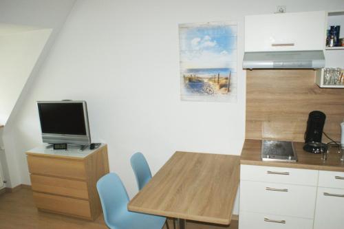 a kitchen with a table and a desk with a computer at Appartament im Herzen von Nürnberg in Nürnberg