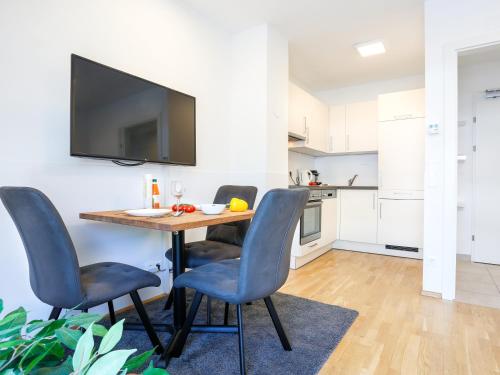 a dining room table with chairs and a tv on a wall at SKY9 Penthouse Apartments in Vienna