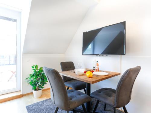 a dining room table with chairs and a tv on the wall at SKY9 Penthouse Apartments in Vienna