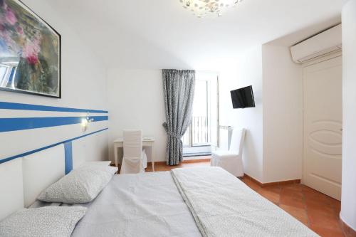 a white bedroom with a bed and a window at Casa Ponticeto in Ravello