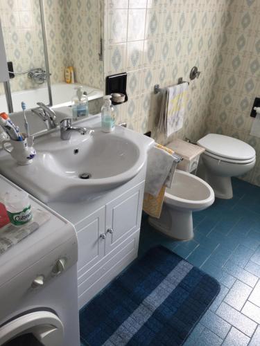 a bathroom with a white sink and a toilet at Viale Europa 91 Appartamento in Pietra Ligure