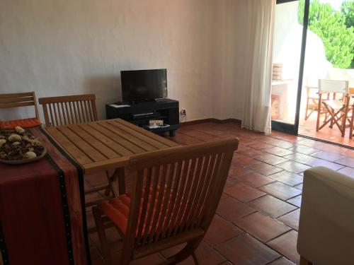 sala de estar con mesa y TV en Vila Fuzeta - Solar dos Mouros, en Porches
