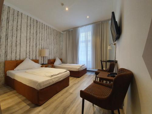 柏林的住宿－埃拉格酒店，酒店客房 - 带两张床、一张桌子和一把椅子