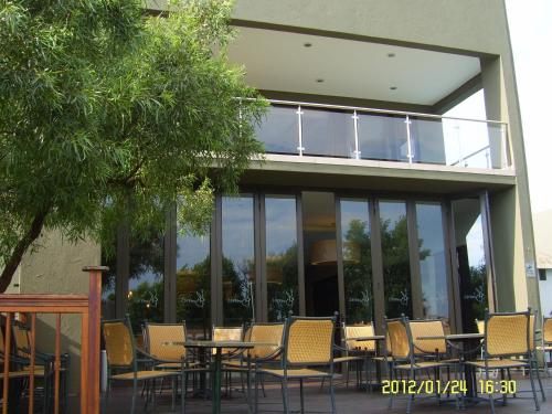 a group of tables and chairs in front of a building at Umuzi Lodge in Secunda