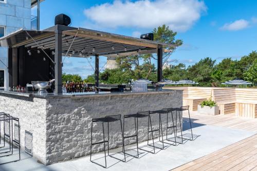 an outdoor bar with stools and a grill at First Hotel Kokoloko in Visby