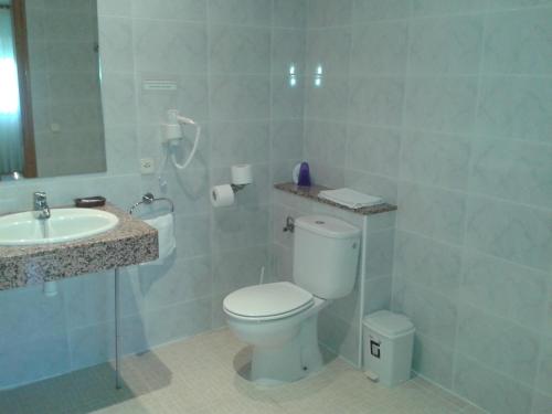 a bathroom with a white toilet and a sink at Fonda Finet in Sant Felíu de Pallarols