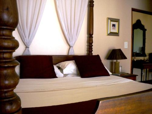 a bedroom with a large bed with a large window at MAVILLA STELLENBOSCH B&B in Stellenbosch