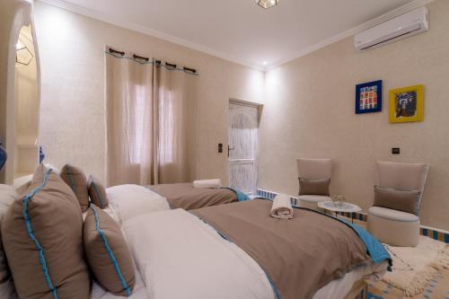 a hospital room with two beds and two chairs at Riad Chebbi in Merzouga