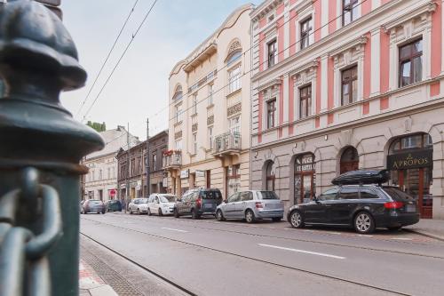 een rij auto's geparkeerd op een stadsstraat met gebouwen bij Apartment Amaretto Długa 60 by Renters in Krakau