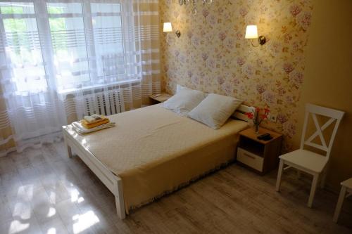 a bedroom with a bed and a chair and a window at Квартира у моря на Фонтане Аркадия Одесса in Odesa