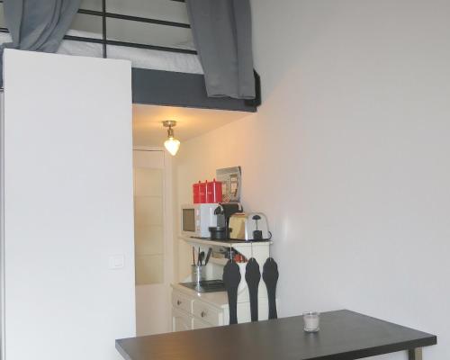 - une cuisine avec une table et une cafetière dans l'établissement Studio Bastille Lappe CityCosy, à Paris
