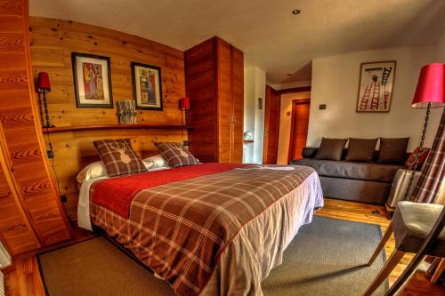 a bedroom with a bed and a couch at Maison Perriere - Chambres d'hôtes & Jacuzzi in Saint Vincent