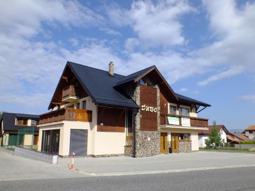 a building with a black roof on a street at Penzión Dubo in Liptovský Mikuláš