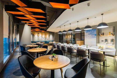 a restaurant with tables and chairs and a bar at Atour Hotel Ningbo High-tech Zone Jiangnan Road in Ningbo