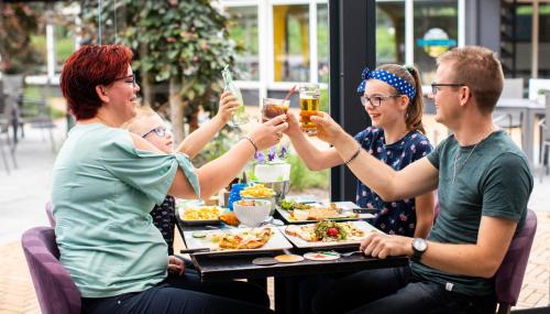 um grupo de pessoas sentadas em torno de uma mesa bebendo cerveja em TopParken – Recreatiepark ’t Gelloo em Ede