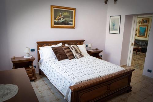 1 dormitorio con 1 cama, 2 mesas y una foto en la pared en Villa Anna, en Bari