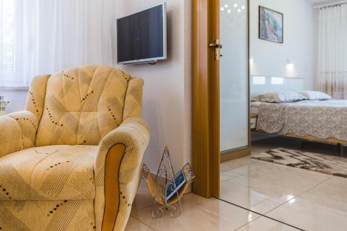 a living room with a chair and a bedroom at Apartmani Katica in Povile