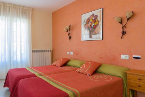 um quarto com uma cama com paredes cor de laranja em Pension Areas em O Pindo
