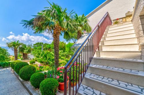 a staircase with a palm tree next to a building at Apartmani Katica in Povile